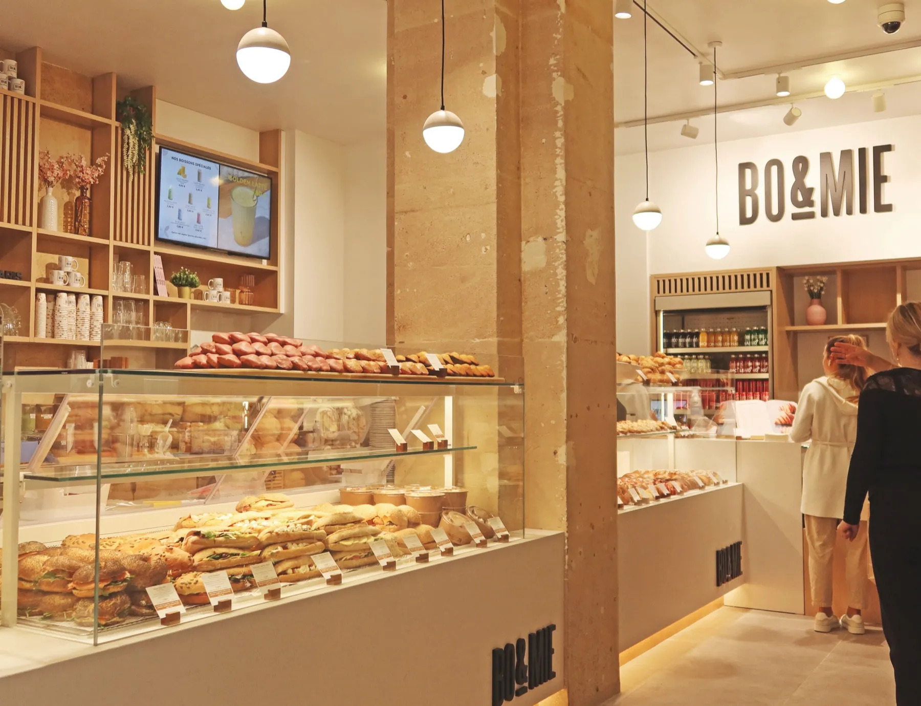 Le comptoir de BO&MIE Hôtel de Ville : vitrine de sandwichs et de viennoiseries, pilier de pierre et lettres BO&MIE au mur