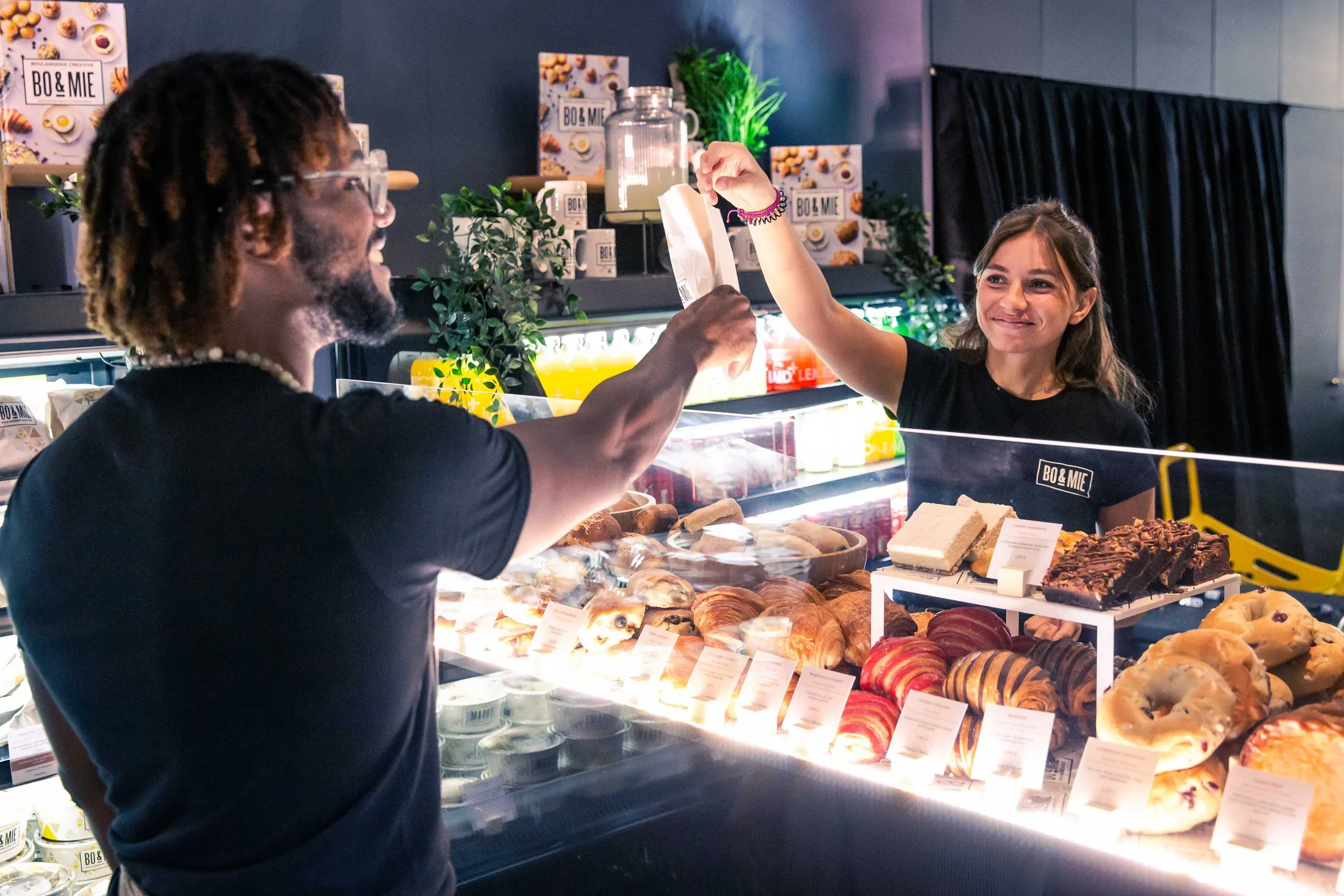 Le comptoir d’une boulangerie BO&MIE, un sachet passe de main en main