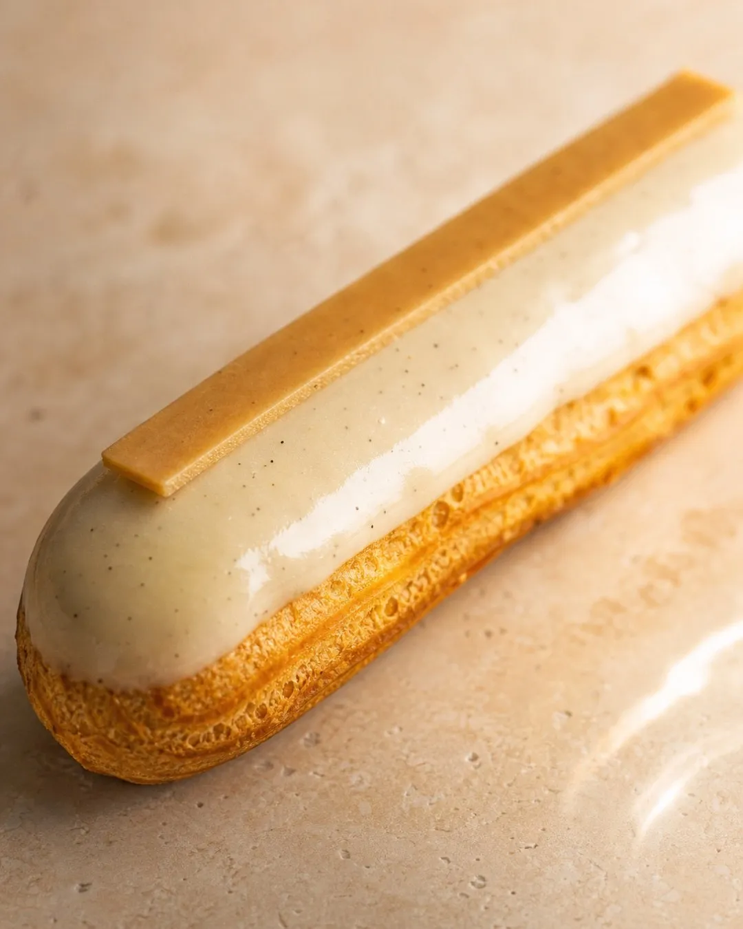 Un éclair BO&MIE à la vanille de Madagascar, glaçage vanillé et bâton de caramel posé sur le dessus