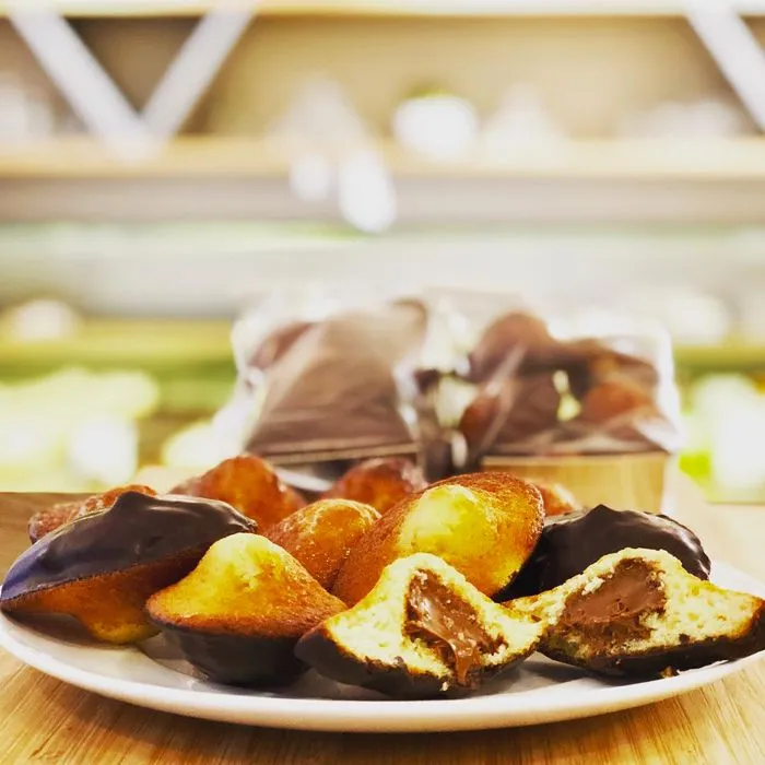 Madeleines BO&MIE glacées au chocolat, l’une ouverte sur son cœur praliné coulant