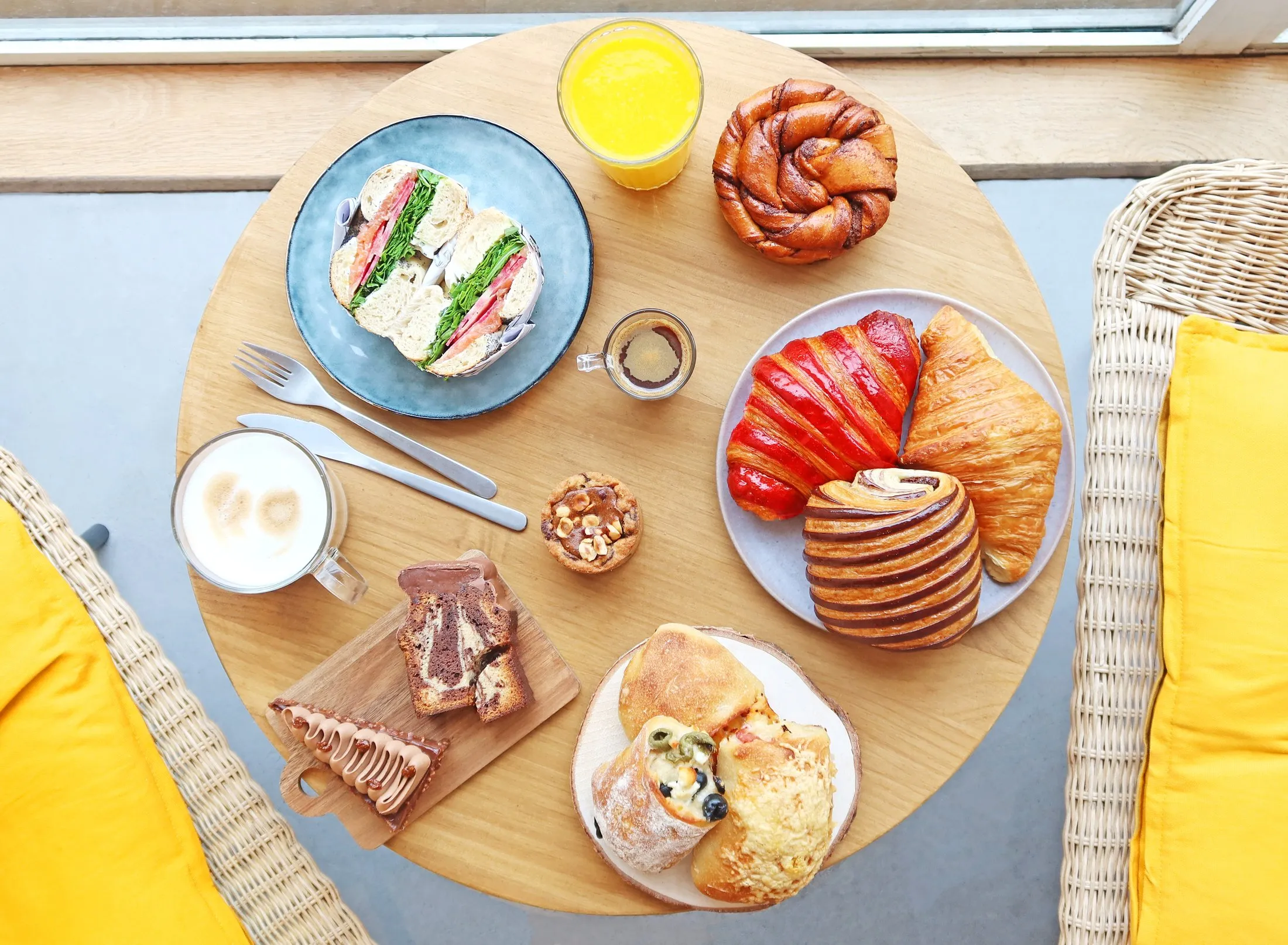 Une table BO&MIE vue de dessus : espresso, cappuccino, viennoiseries et sandwich