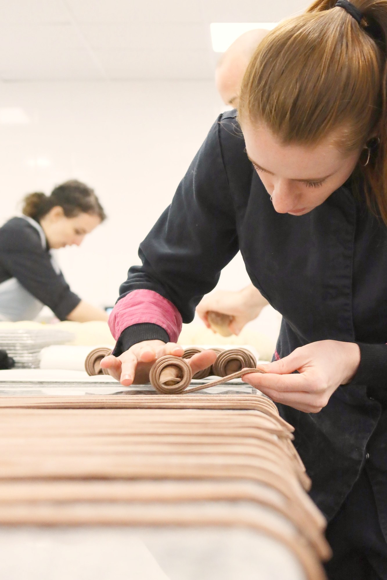 Tourière BO&MIE roulant une bande de feuilletage sur le marbre de l’atelier